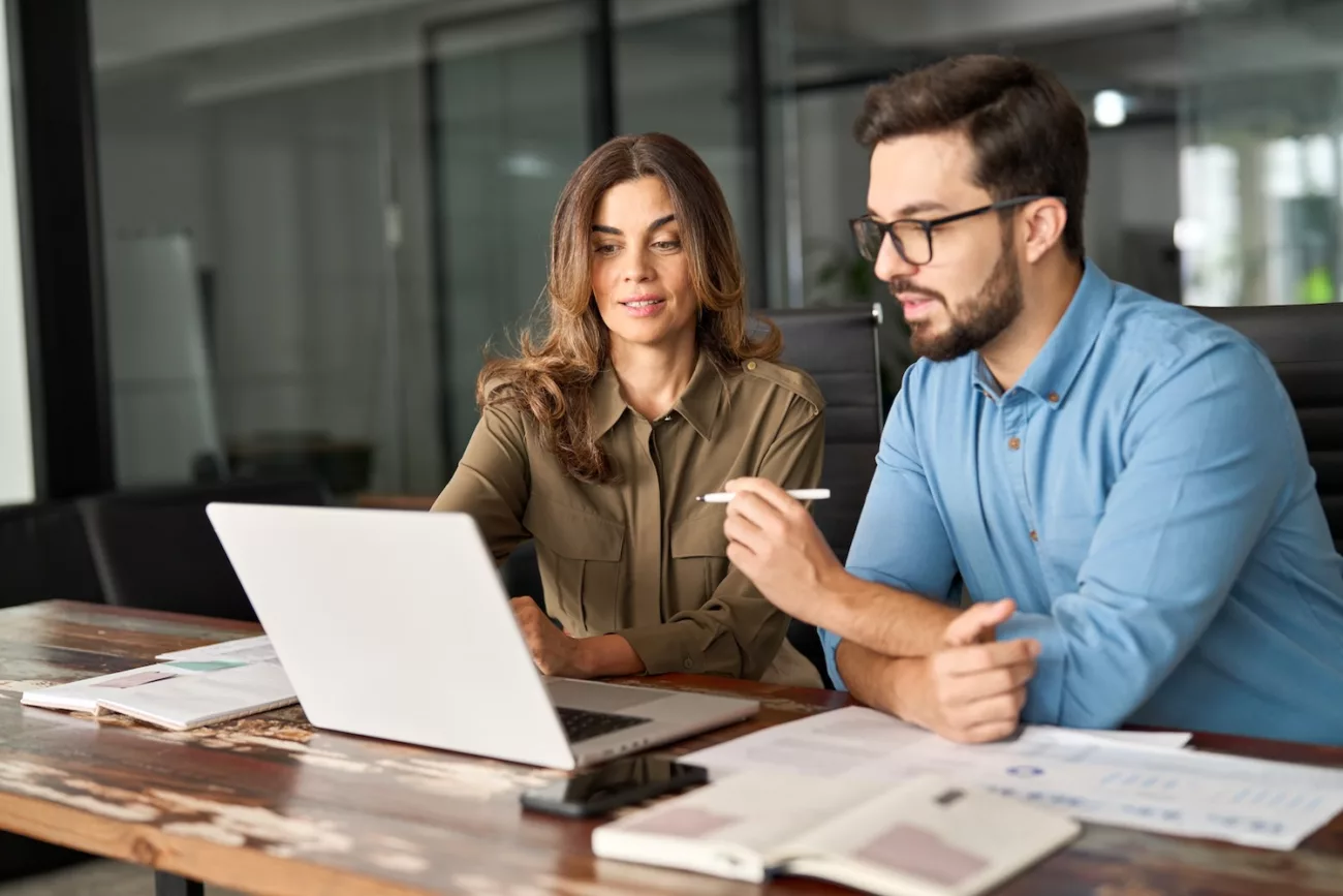 vous dabord visuels original name 10 two busy colleagues working together talking using laptop in office